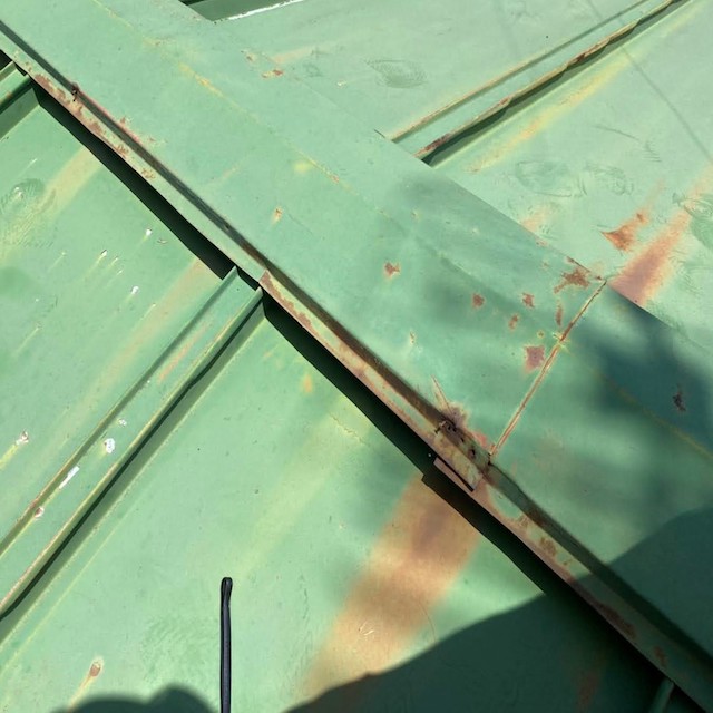 錆びの進行が激しい緑色の金属屋根